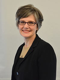 Portrait of woman in glasses wearing a black suit